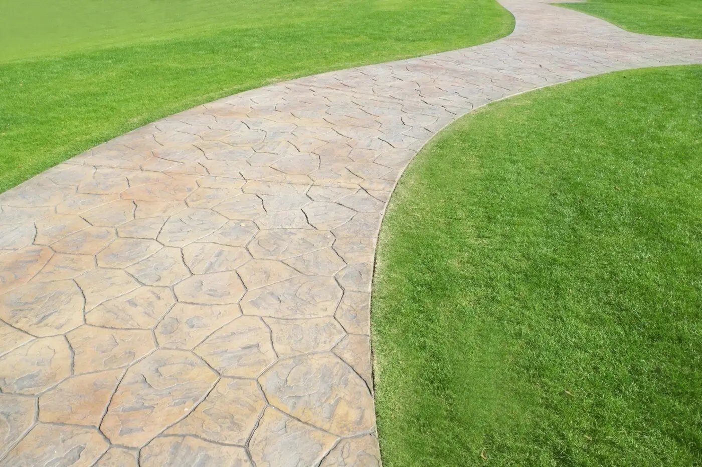 natural stone walkway with artificial grass surrounds to create a stunning patio in Jupiter FL